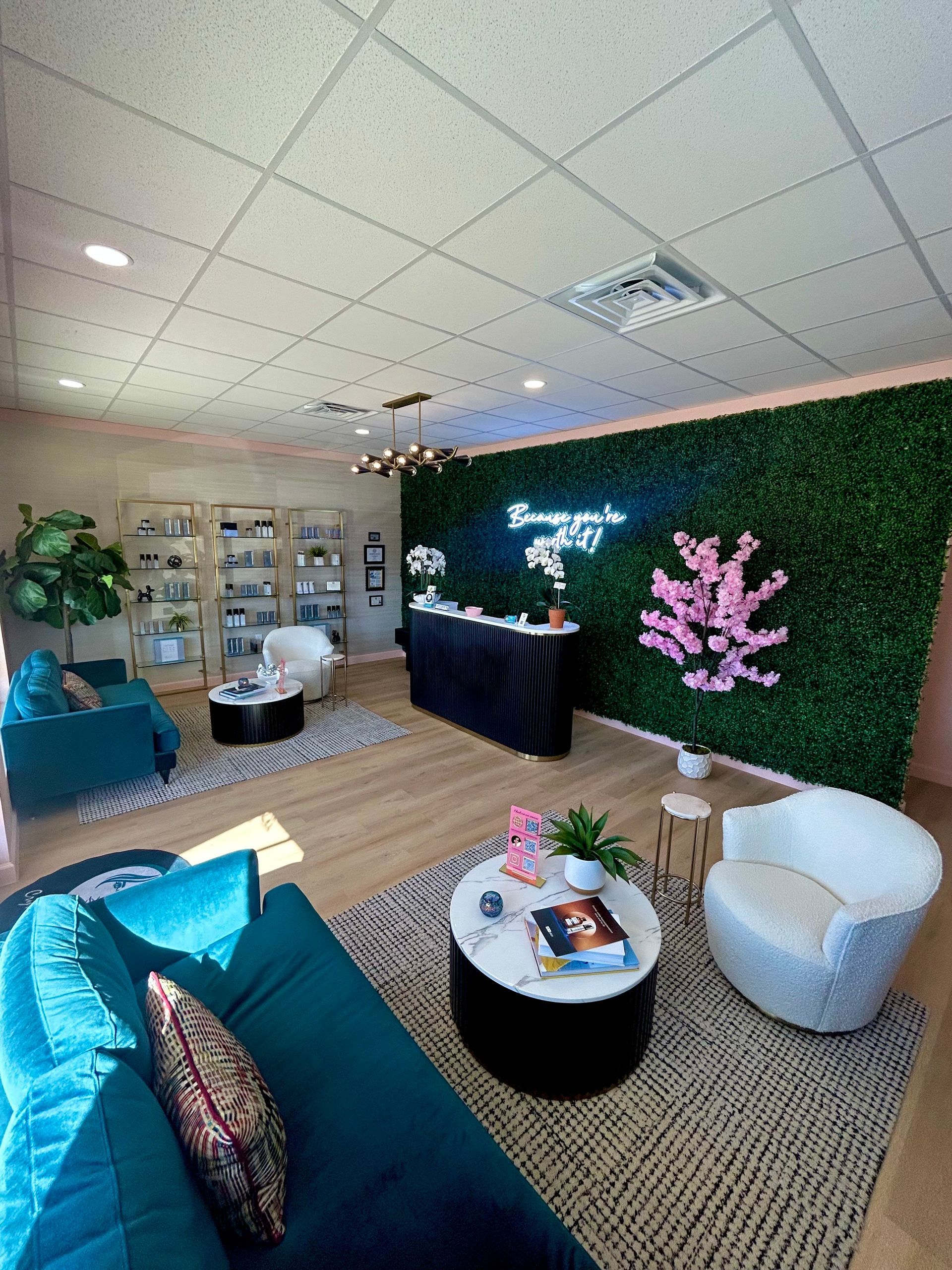A living room with a couch , chairs , tables and a green wall.