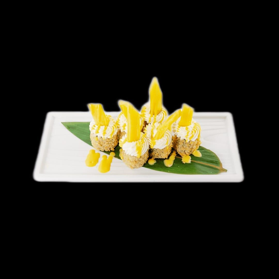 Un piatto bianco sormontato da un dolce e una foglia su uno sfondo nero.