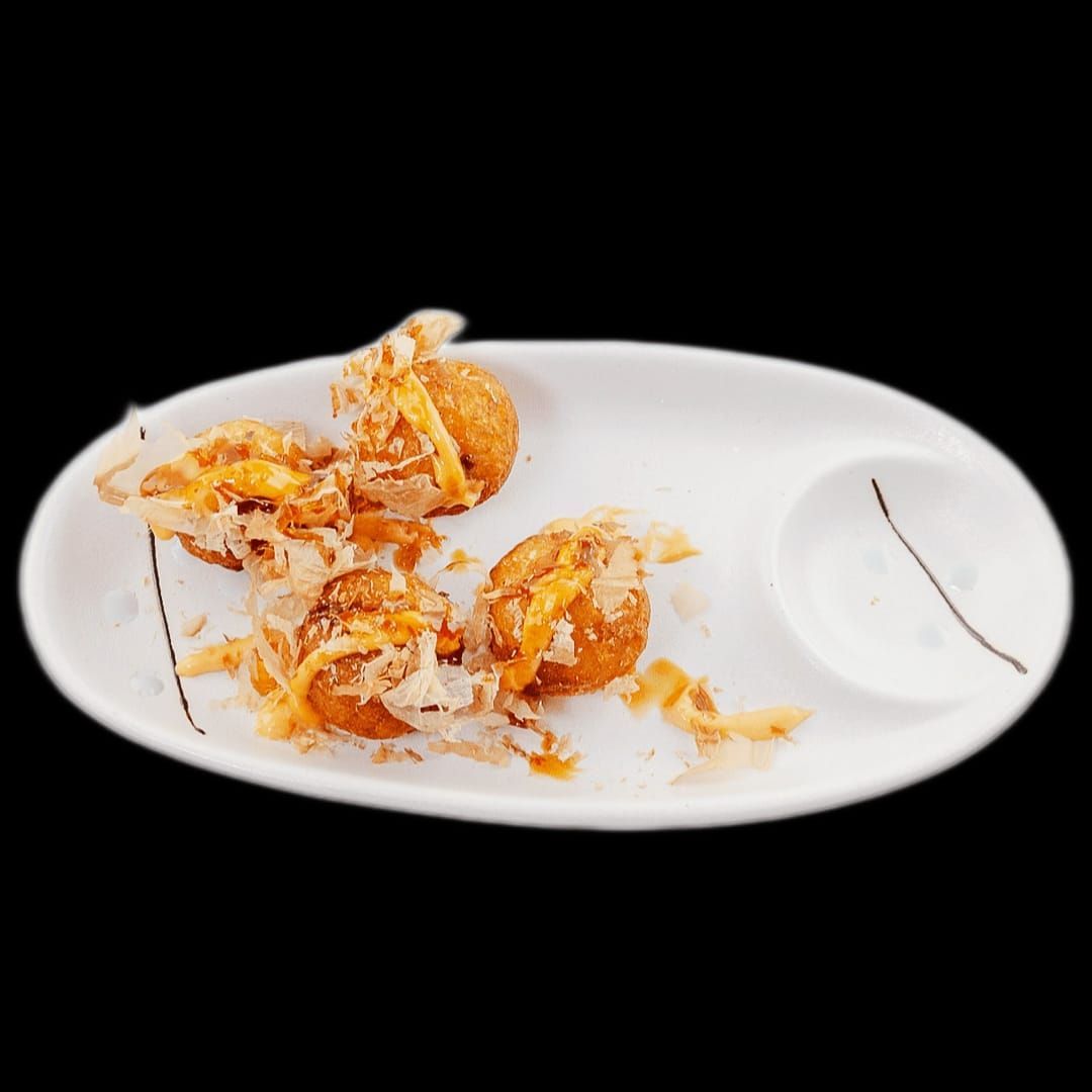 Un piatto bianco con sopra cibo fritto e una salsa.