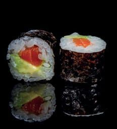 Primo piano di due rotoli di sushi su una superficie nera.