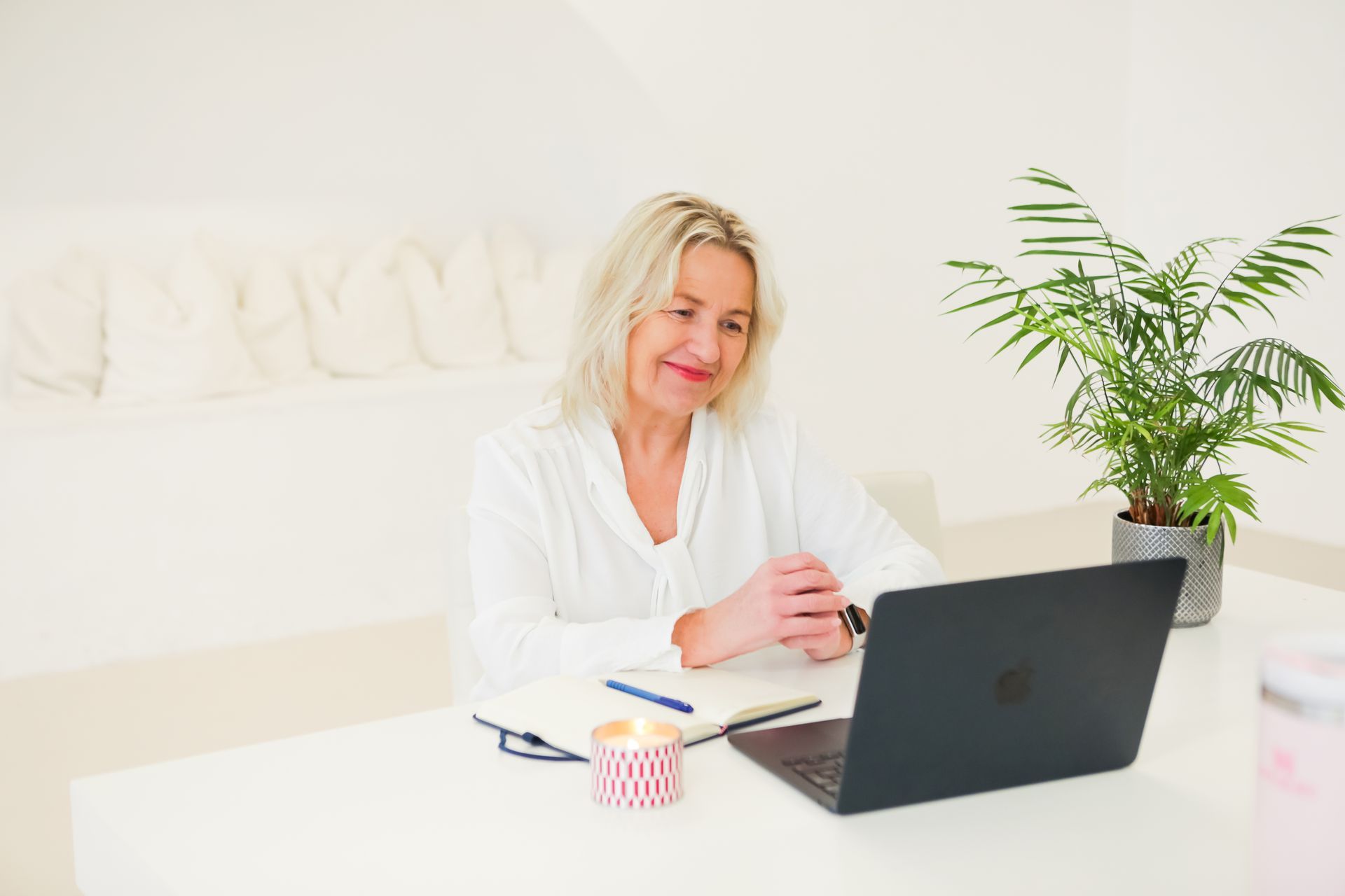 Pam Shanker is sitting at a table with a laptop, In person strategy days, 121 coaching.