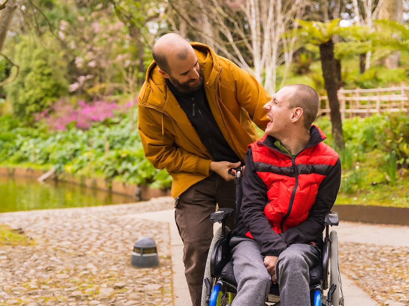 a man guiding another man on a wheelchair