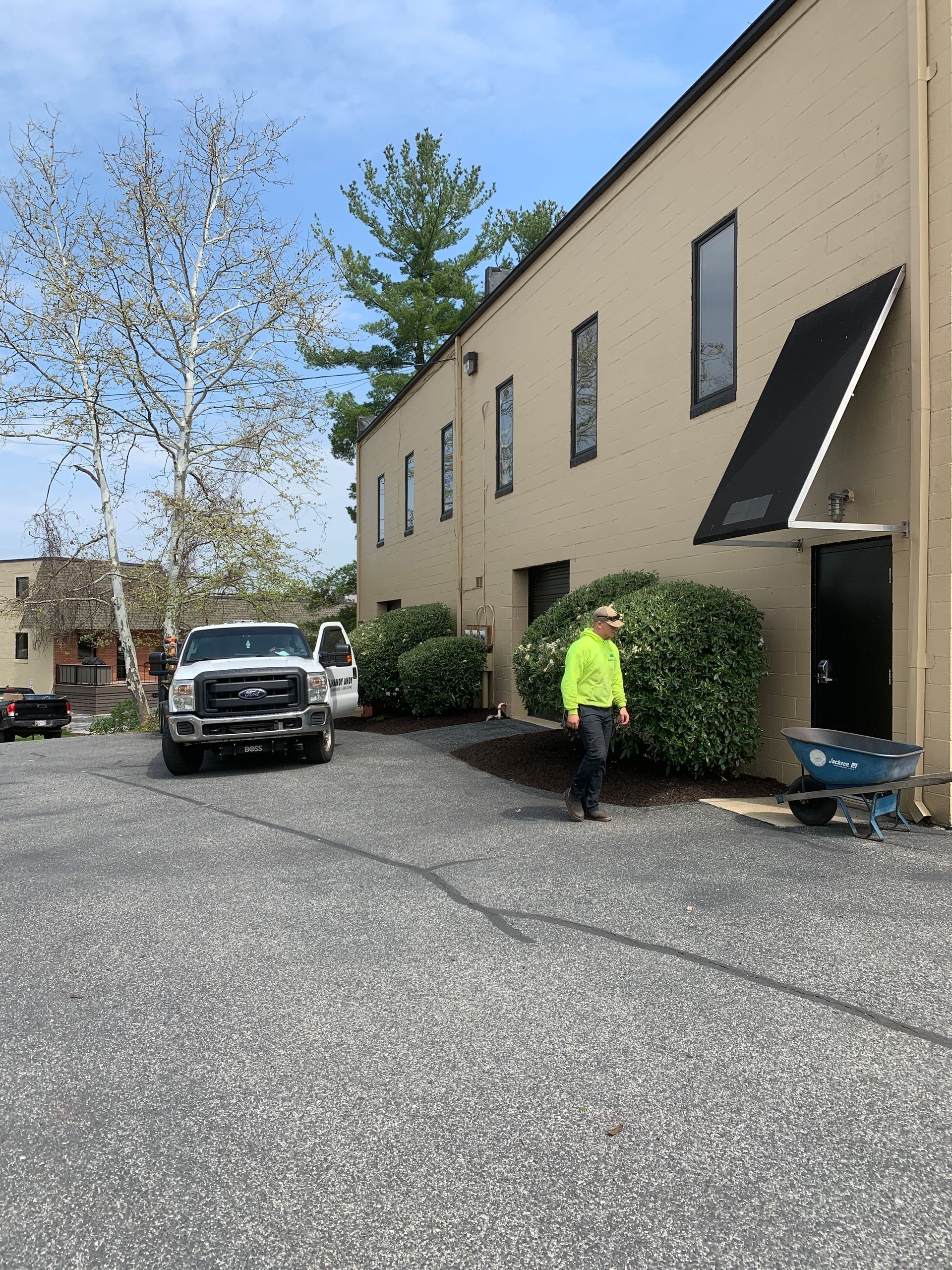 A man in a yellow shirt is walking in front of a building.