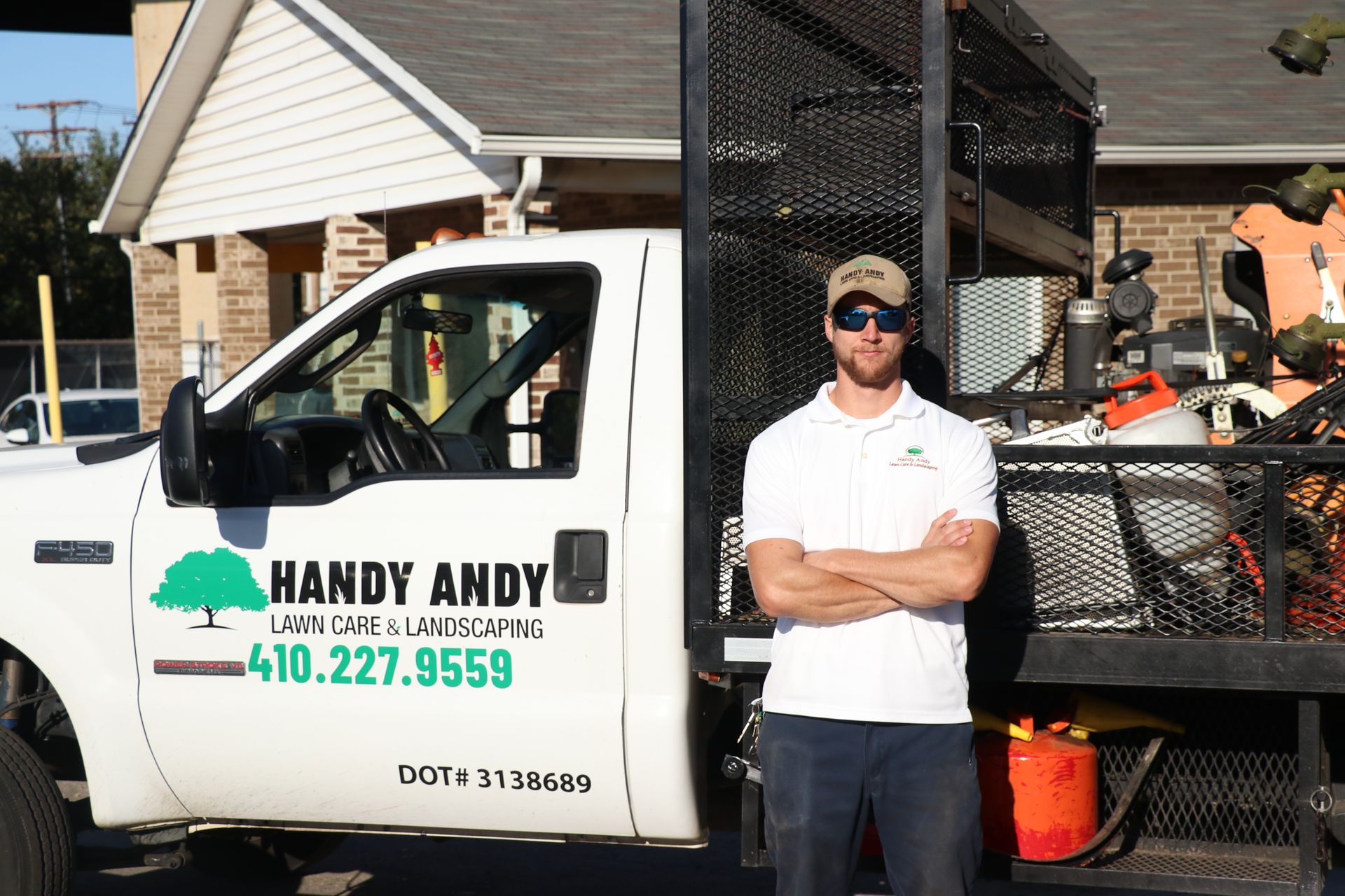 A man is standing in front of a handy andy truck.
