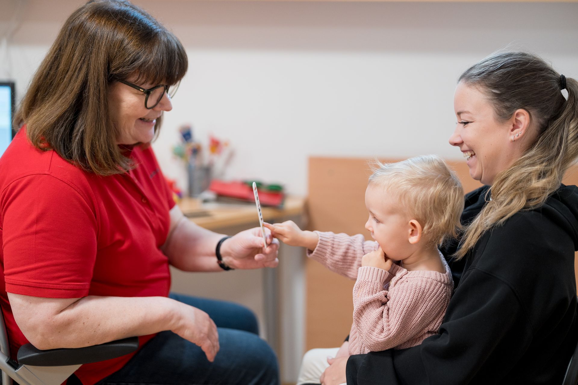 Praxisassistentin der Augenarztpraxis in Feldkirch untersucht ein Kind