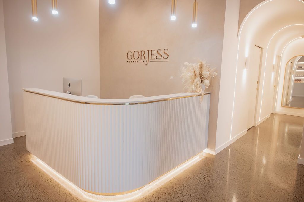 A White Reception Desk in a Hallway With a Computer on It — Gorjess Aesthetics in Corrimal, NSW