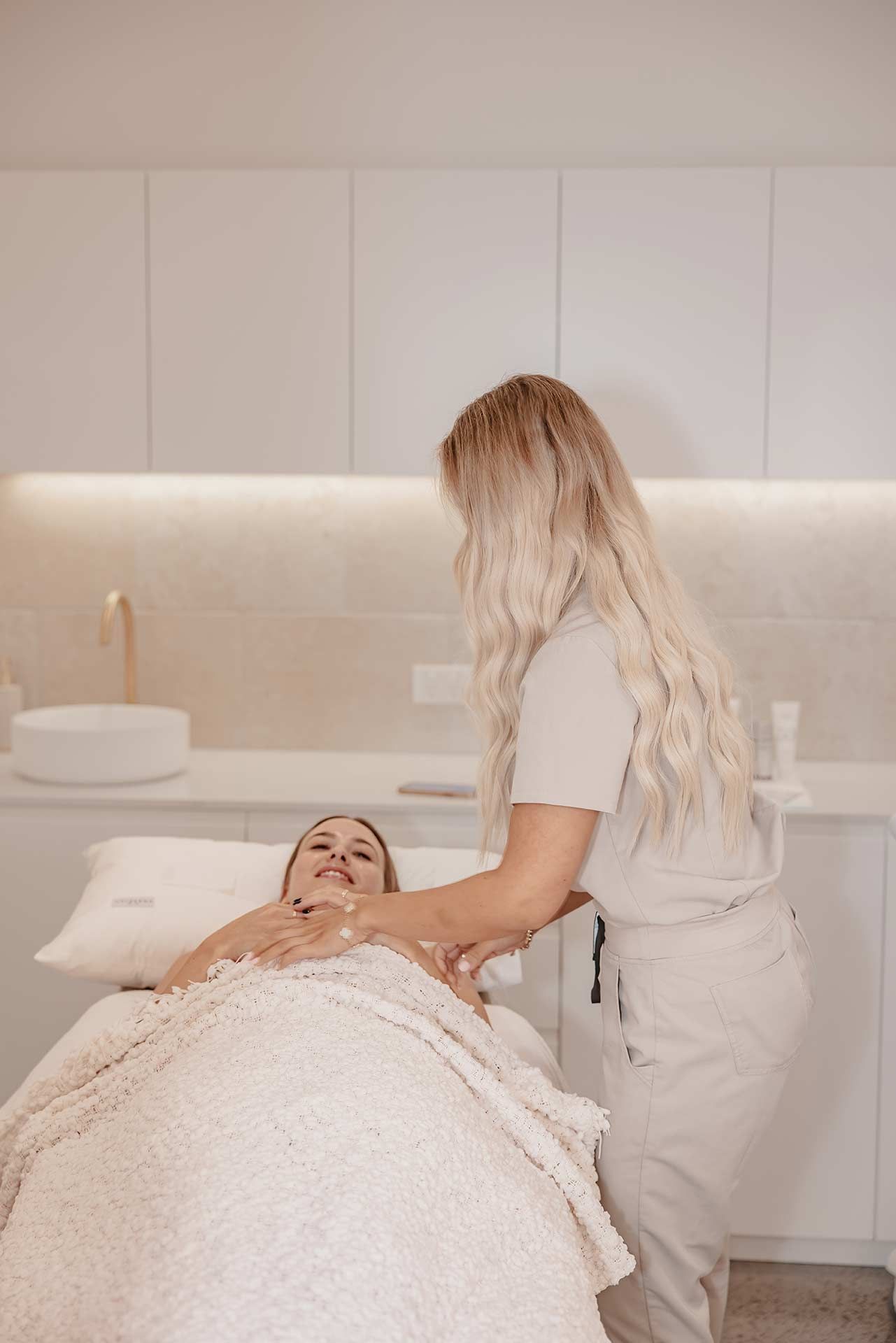 A Woman is Laying in a Chair With a Pink Roller on Her Face — Gorjess Aesthetics in Corrimal, NSW