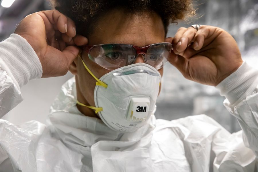 Ein Mann trägt eine Maske und eine Schutzbrille.
