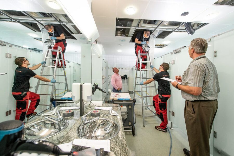 Eine Gruppe von Leuten arbeitet in einem Badezimmer.