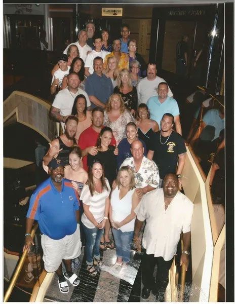 A large group of people are posing for a picture in front of a sign that says 