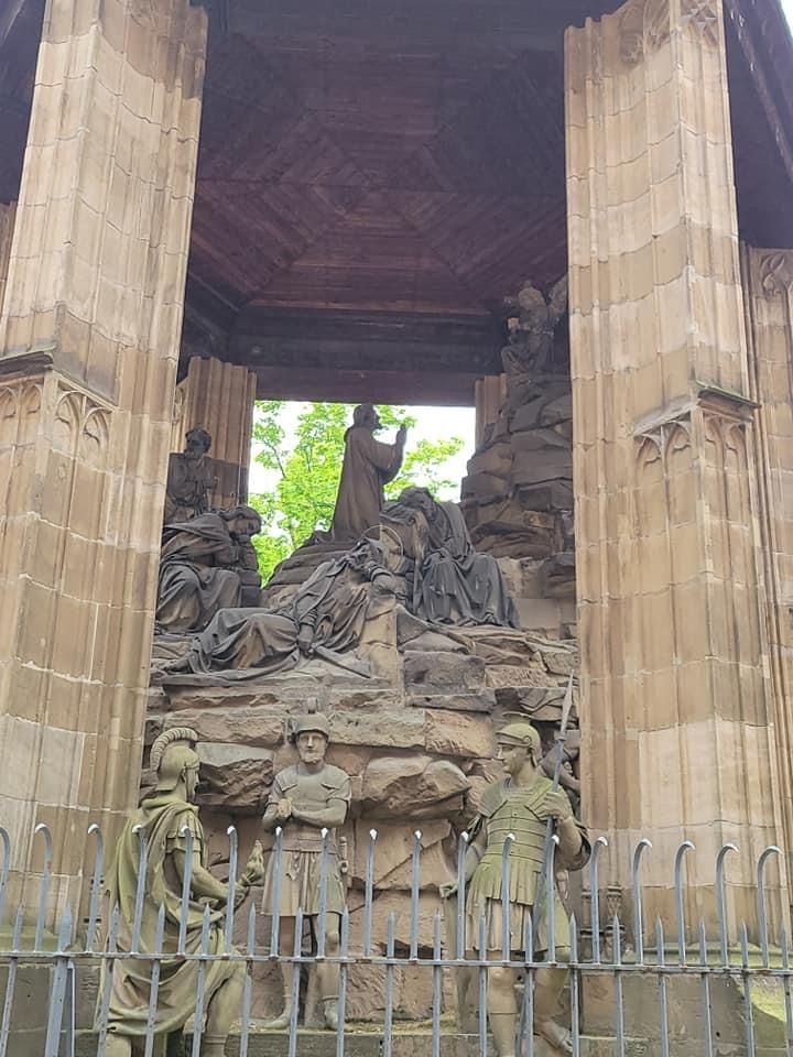 Stone sculpture of figures and a religious scene, within a stone enclosure.