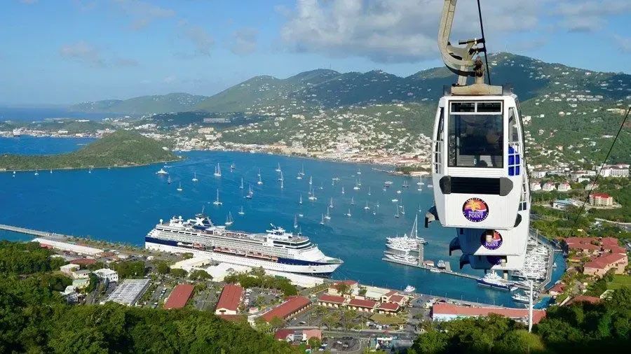 A cable car is going over a body of water.