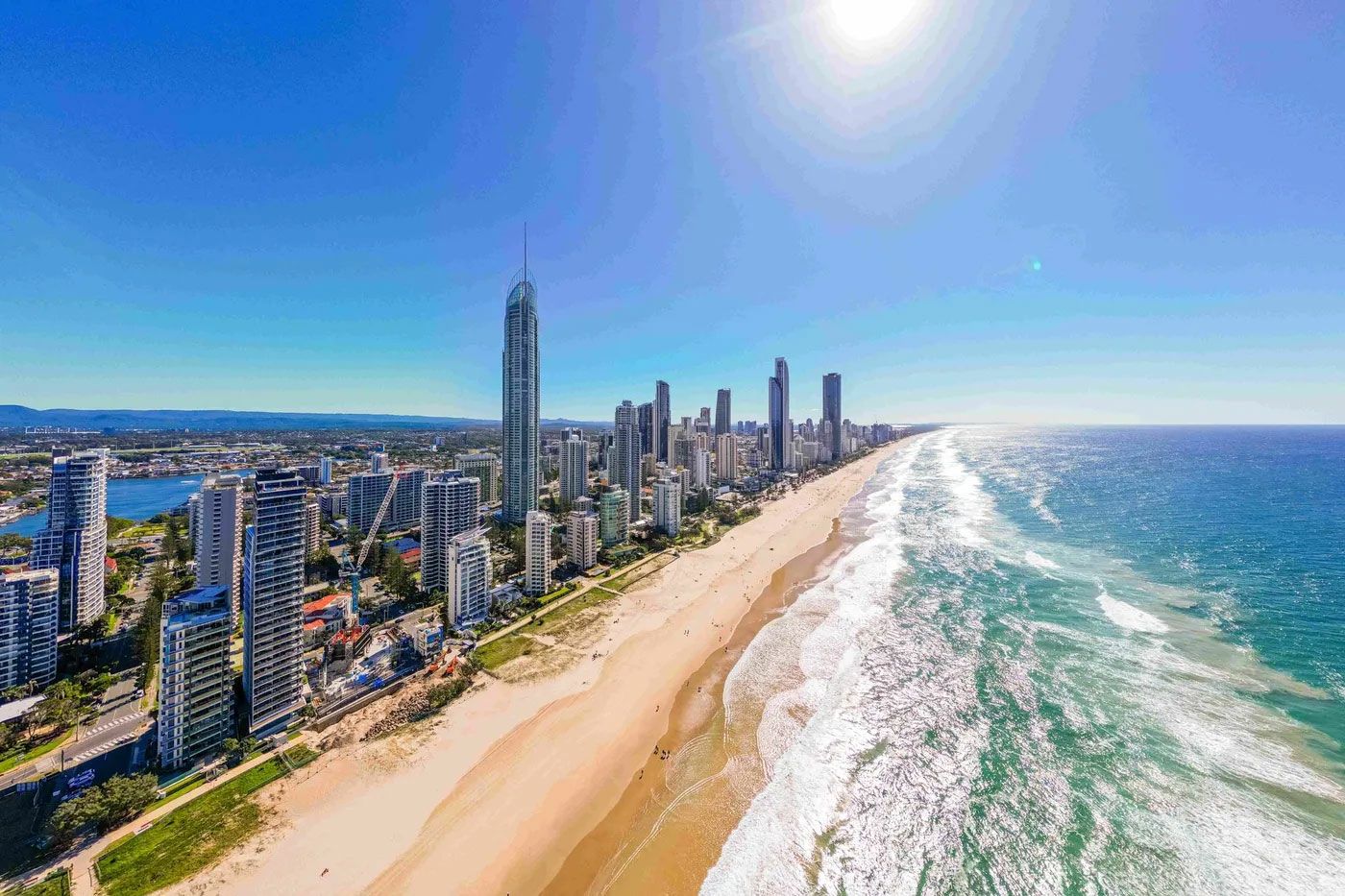 An aerial view of a beach with a city in the background.