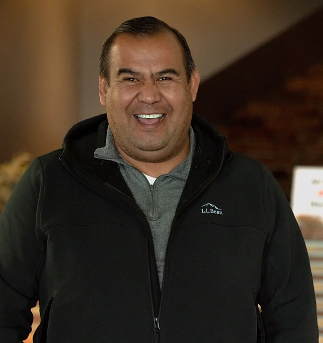 A man wearing a black ll bean jacket smiles for the camera