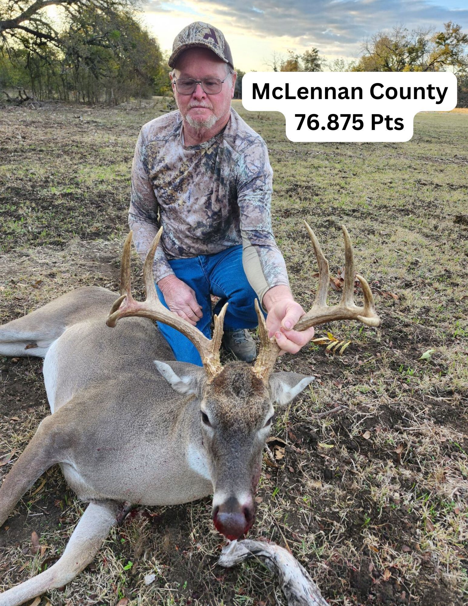 Man in camo with a deer he hunted, in McLennan County.
