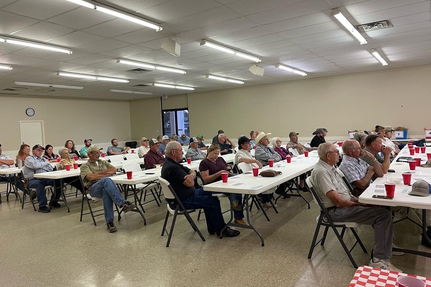 A large group of people are sitting at tables in a room.