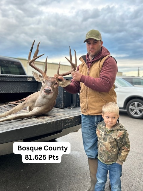 Man and child pose with large buck in Bosque County, Texas. The buck is in a truck bed.