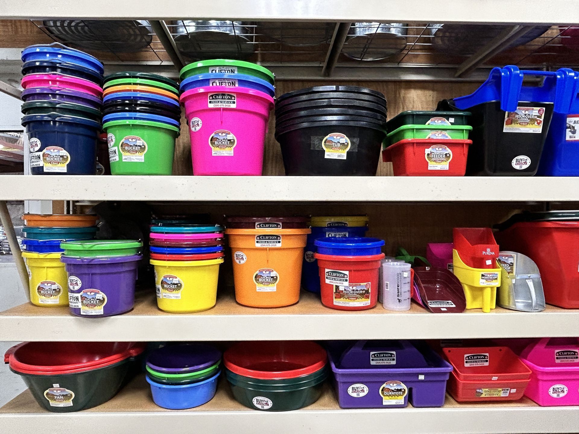 A shelf filled with lots of colorful plastic buckets and bowls.
