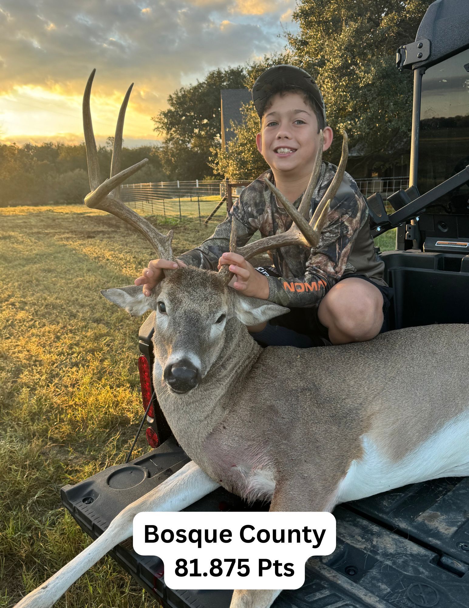 Young boy in camo kneels over a deer he hunted in Bosque County, Texas.