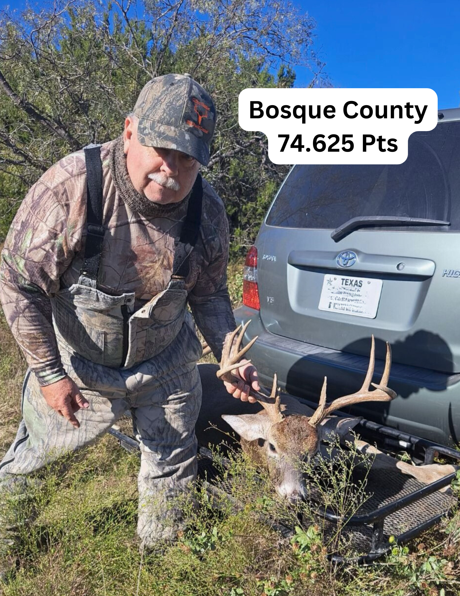 Hunter kneeling beside a deer, near a car, in Bosque County, Texas.