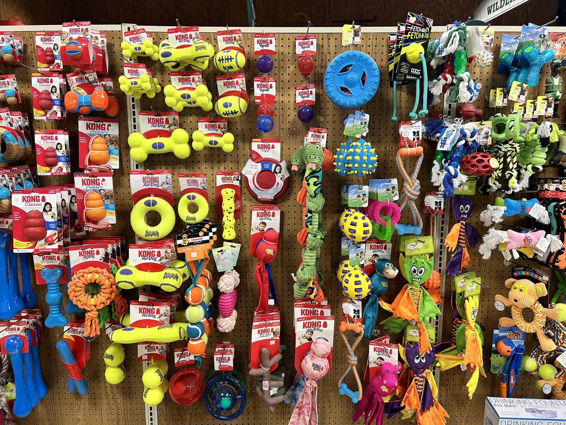 A wall filled with lots of different types of dog toys.