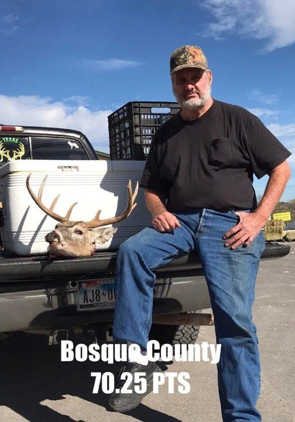 Man in camouflage cap, next to a truck with a deer head. Bosque County, 70.25 PTS.