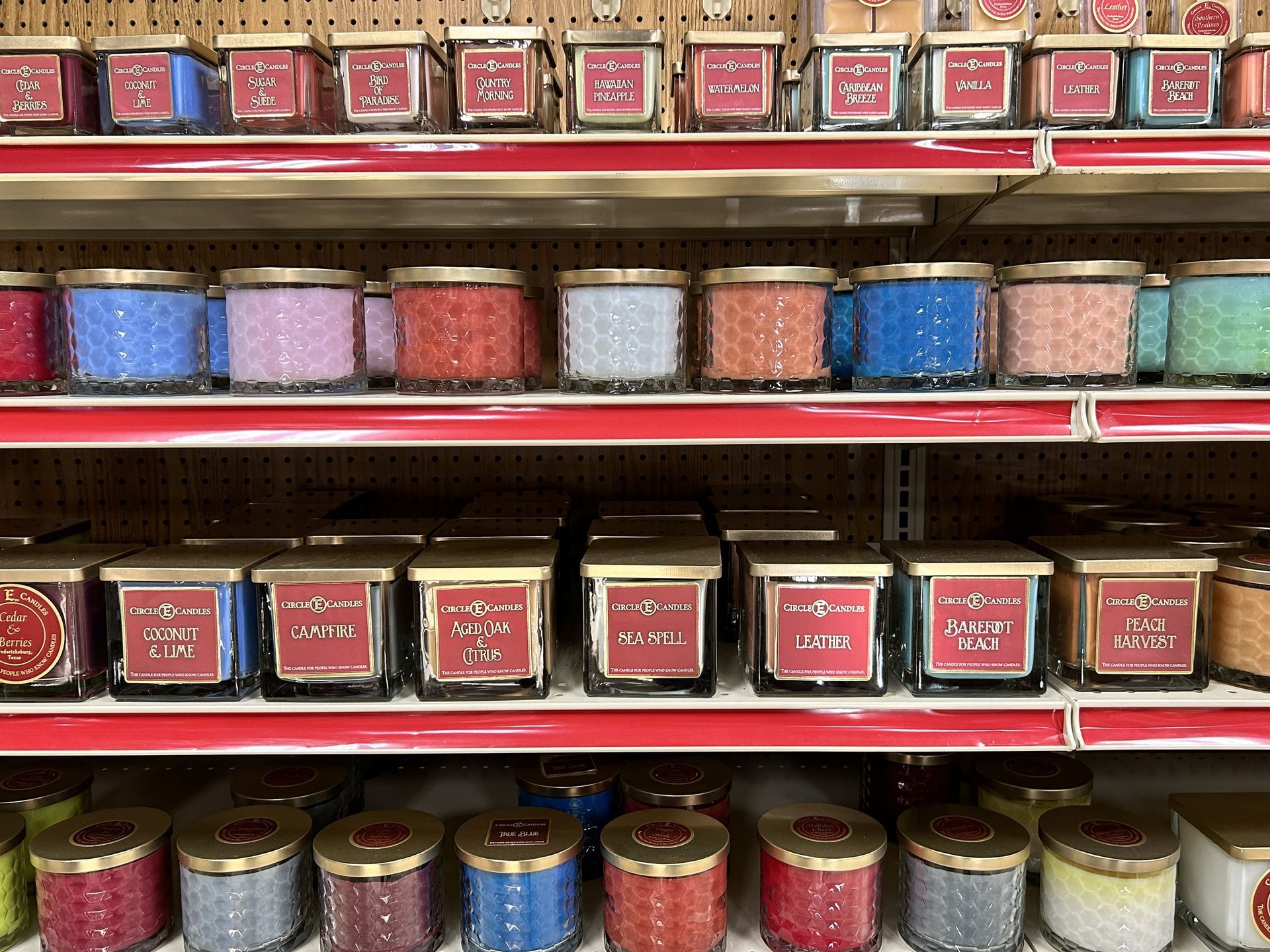 A store shelf filled with lots of different colored candles.