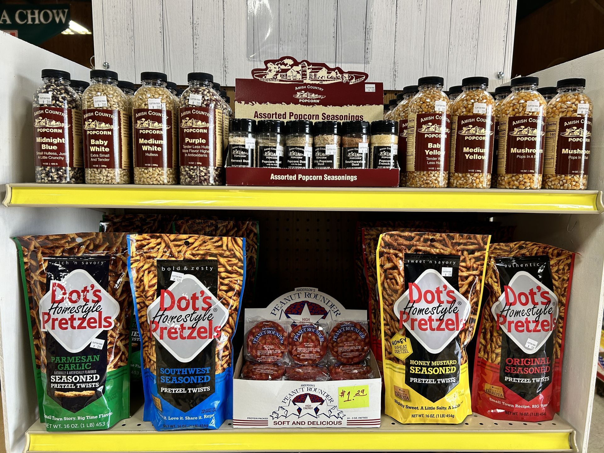 A shelf filled with bags of pretzels and other snacks