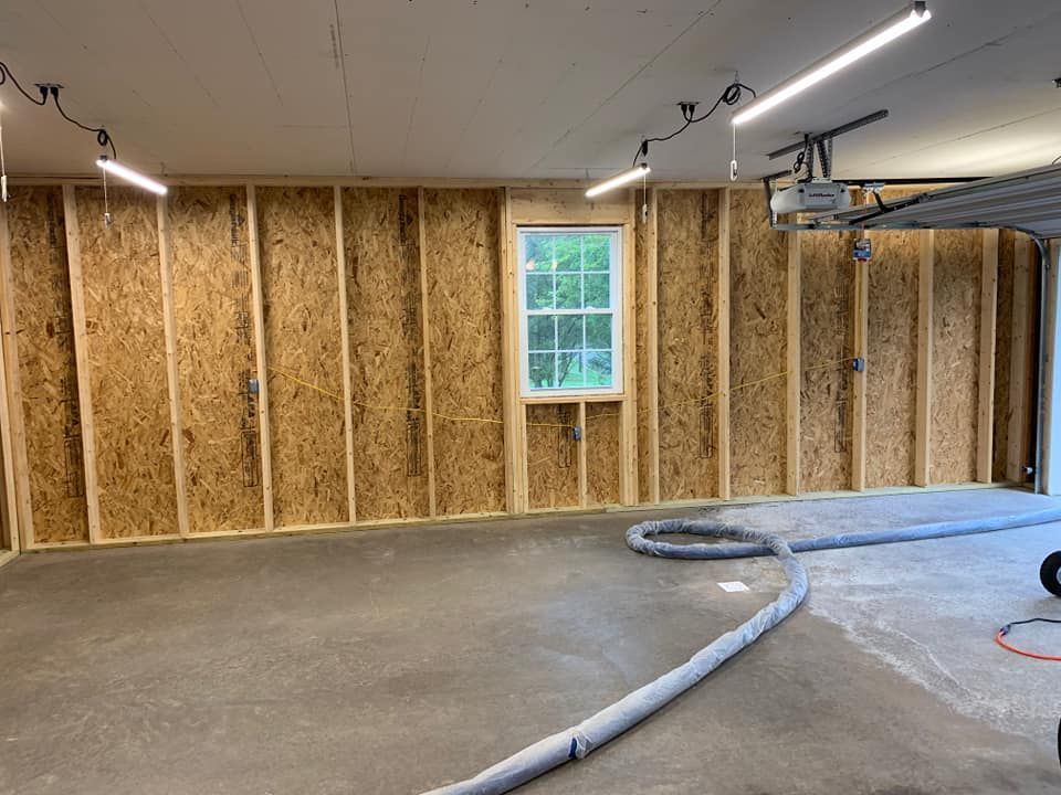 an empty garage with wooden walls and a window .