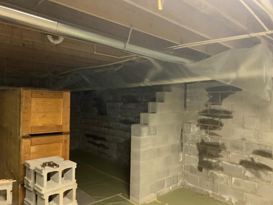 a basement with a staircase and a few boxes stacked on top of each other .