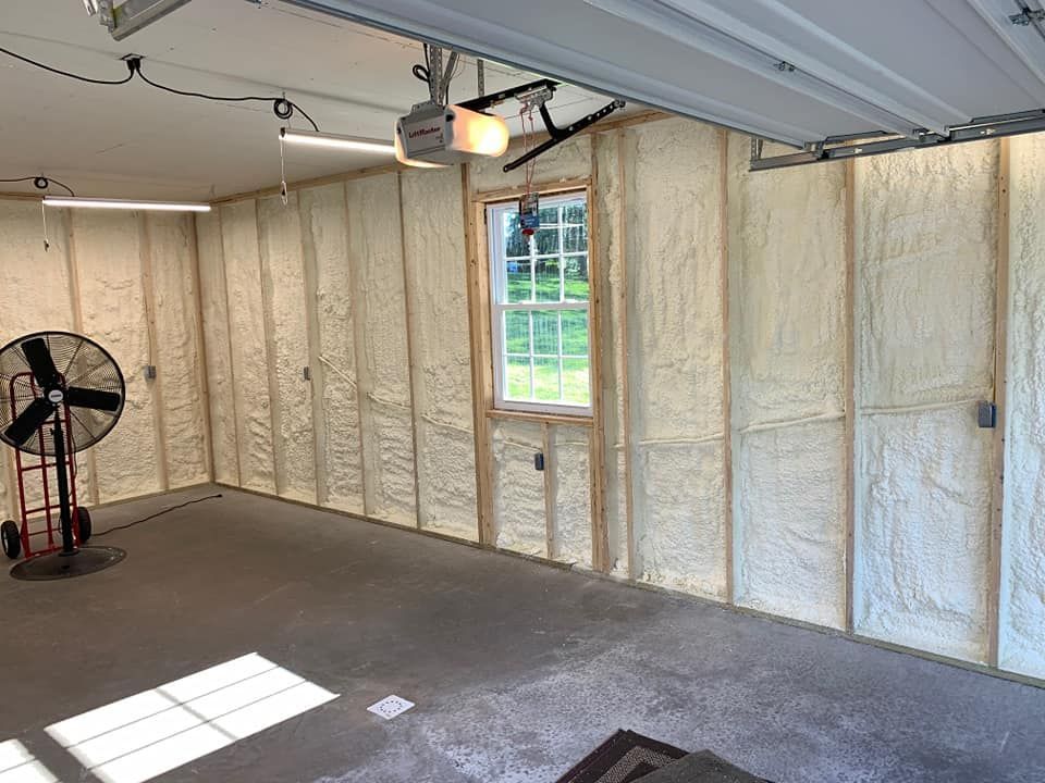 a garage with foam insulation on the walls and a fan .