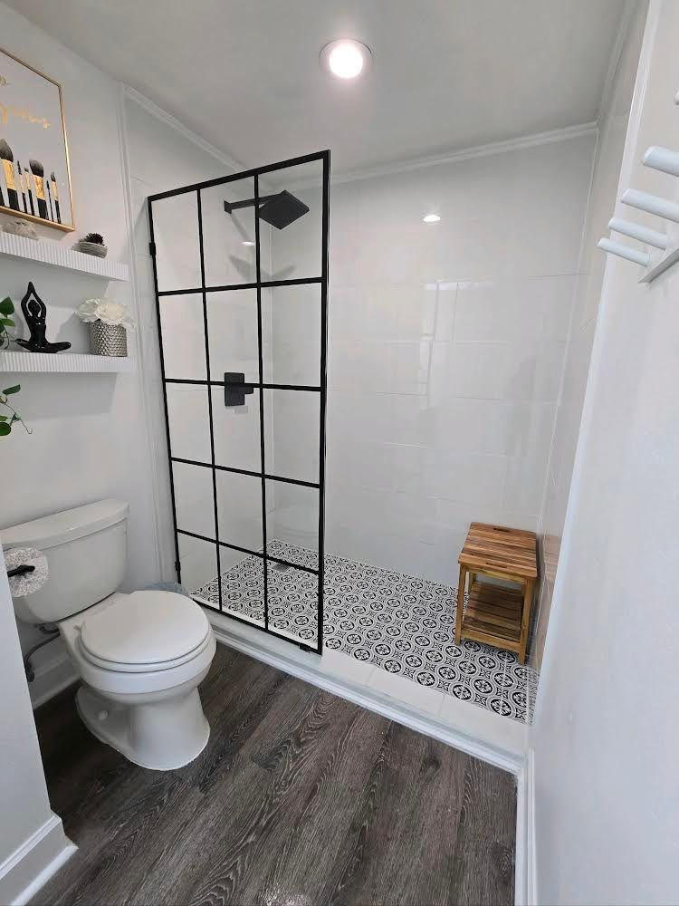 A bathroom with a toilet and a walk in shower.