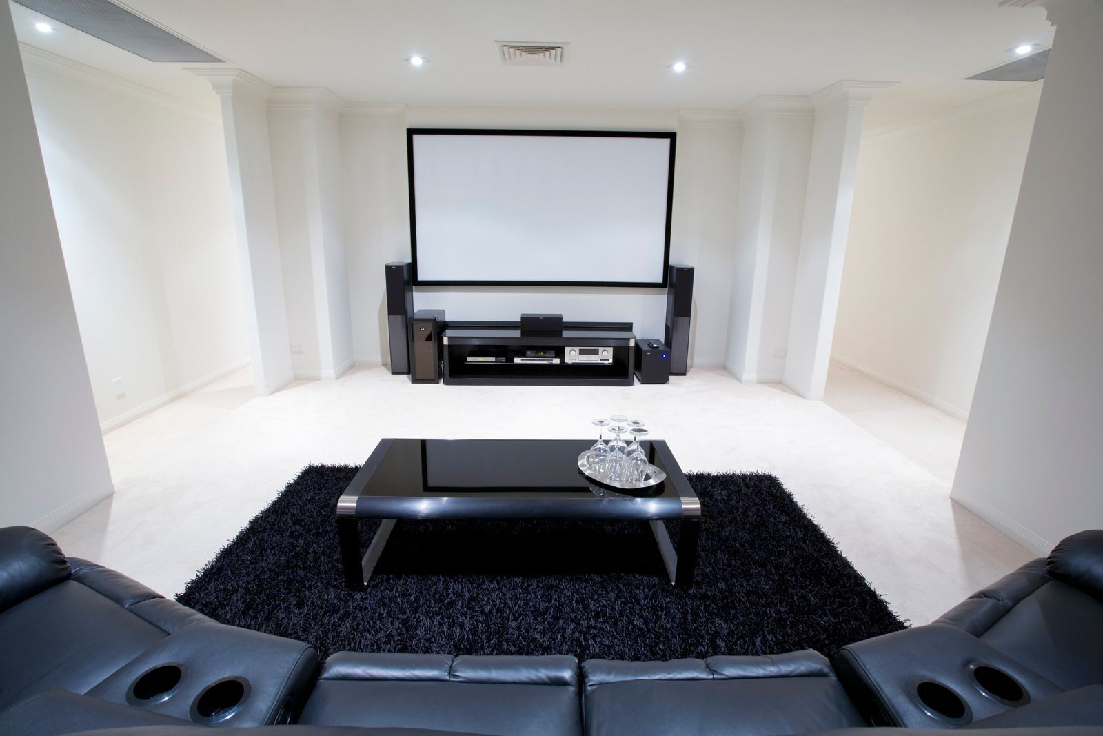 A living room with a projector screen and a couch