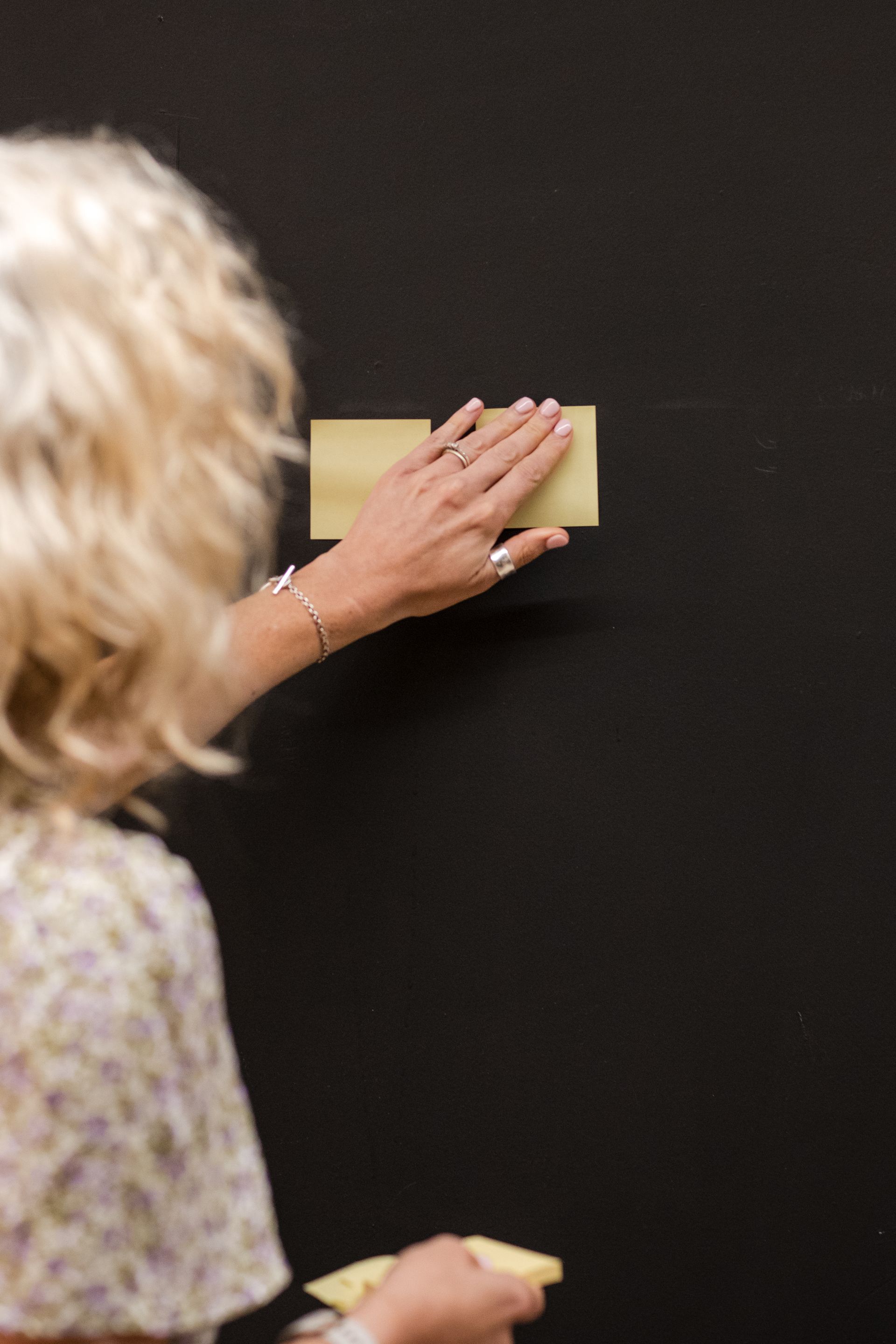 Placing yellow post it notes on a black wall