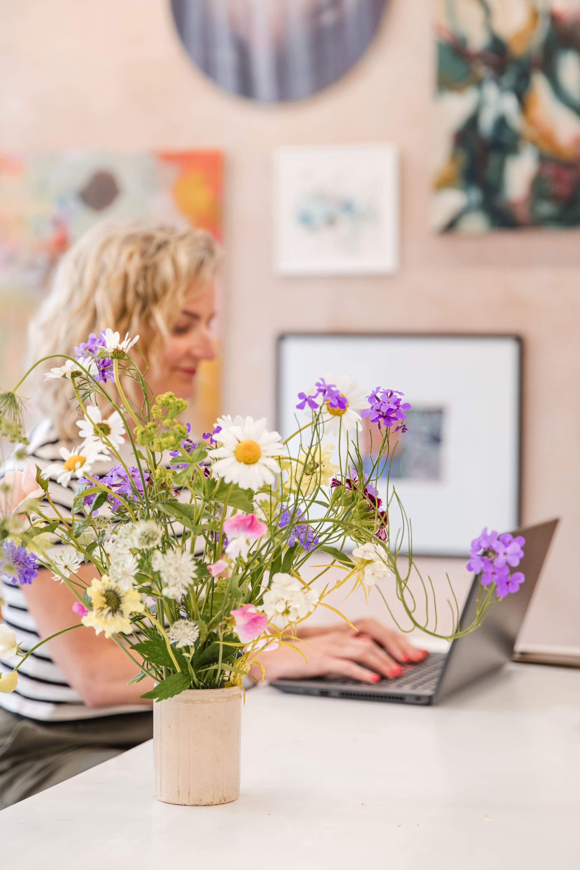 Flowers in the foreground with Nicola working in the background