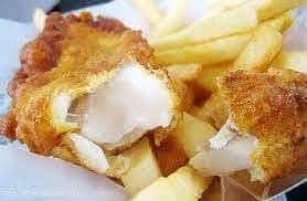 A close up of a plate of fish and chips with a bite taken out of one of the fish.