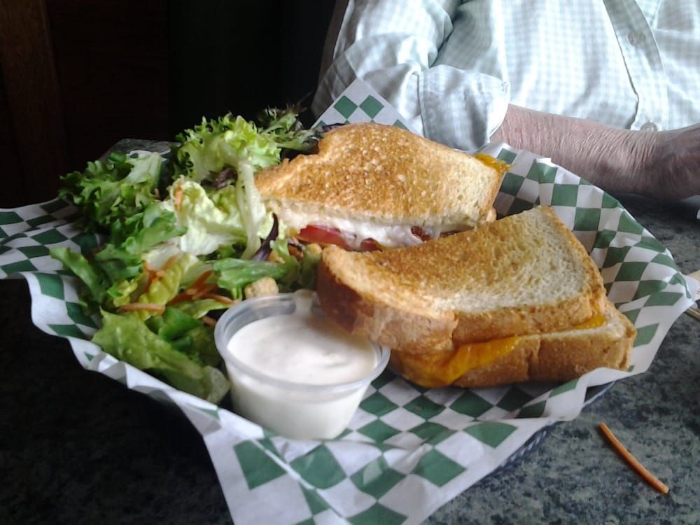 Two sandwiches are sitting on a white plate on a table.