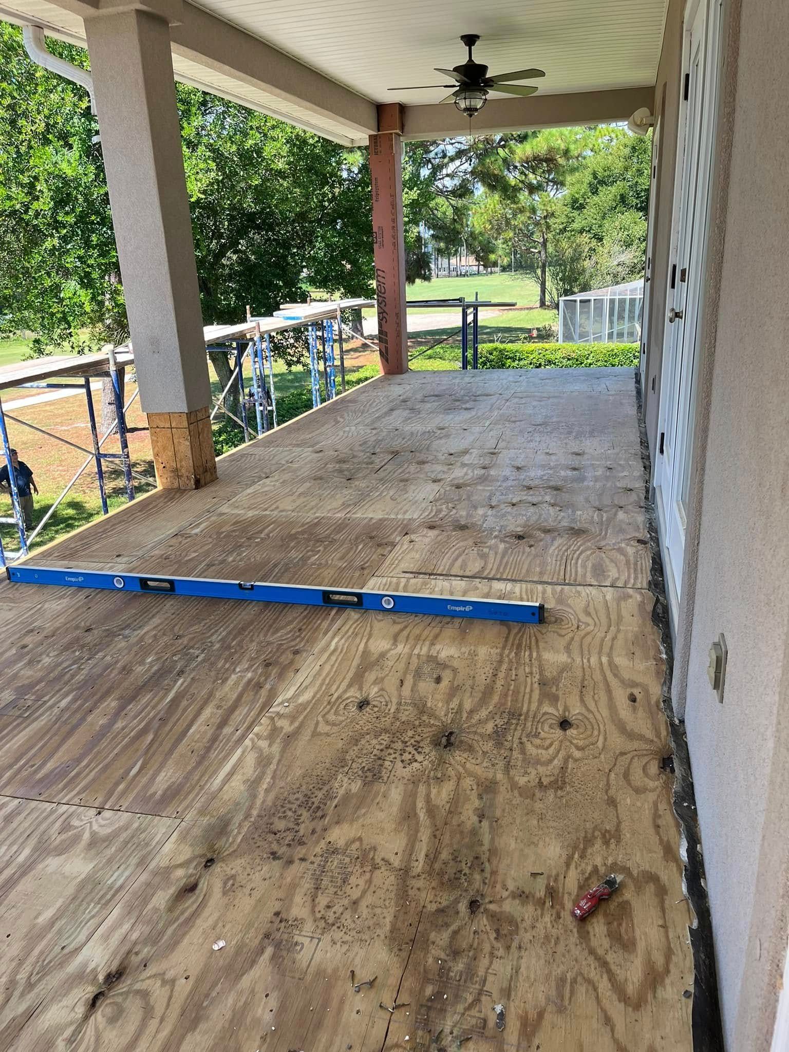 A porch under construction with a level on the floor.
