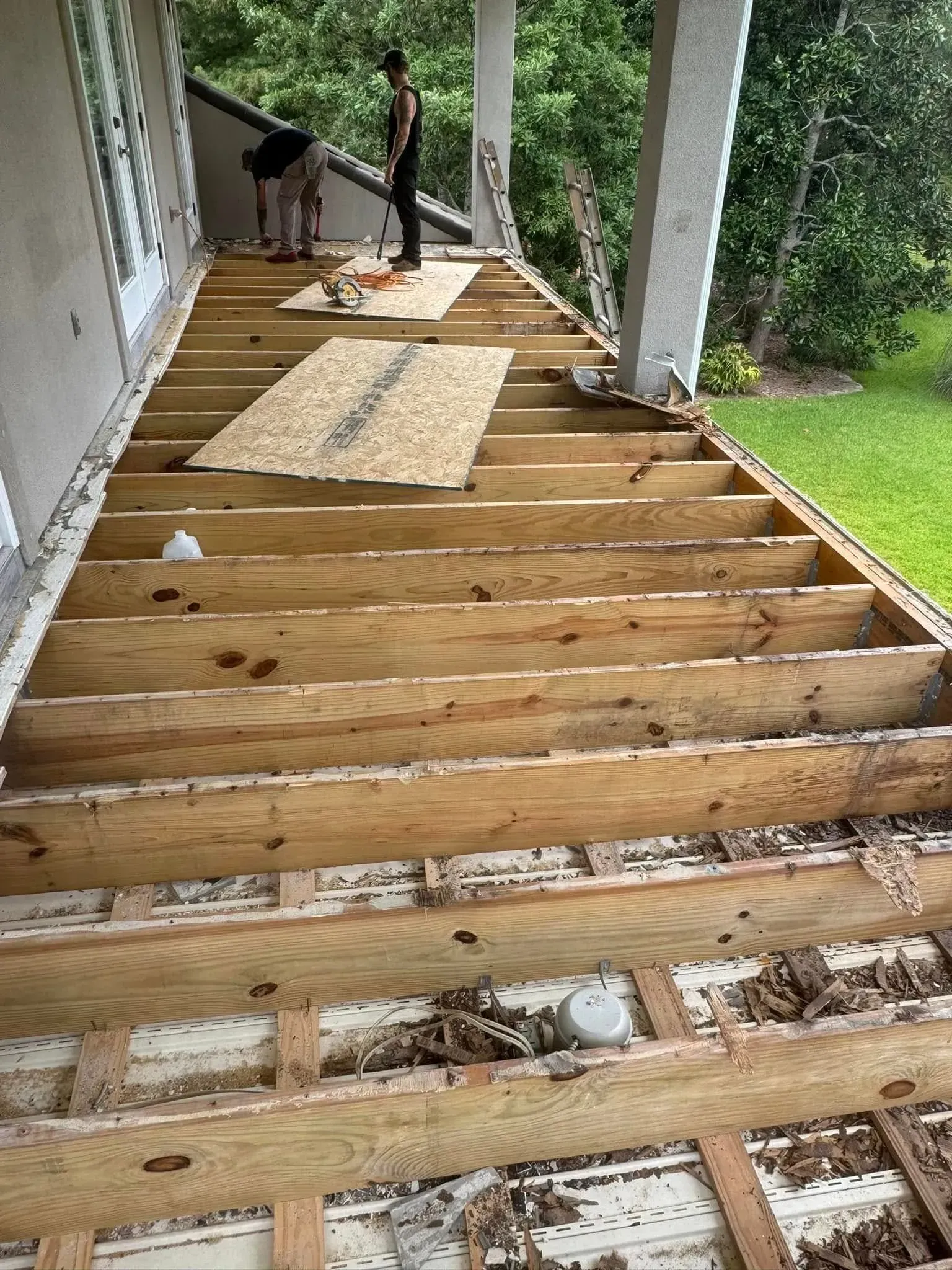 A wooden deck is being built on top of a house.