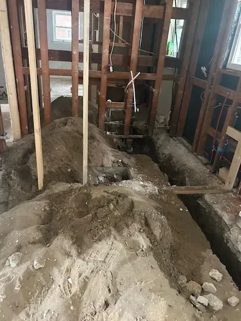 A pile of dirt is sitting in the middle of a room under construction.