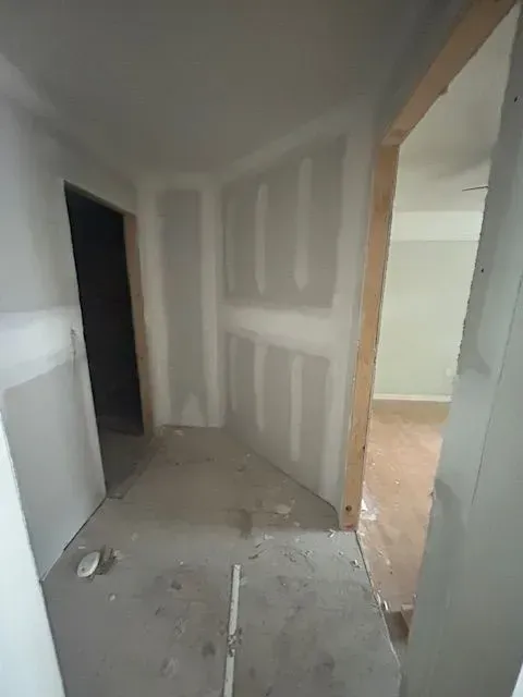 An empty room with drywall on the walls and a door.