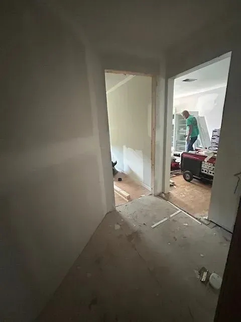 A man is standing in a room next to a door.