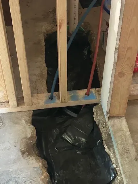 A hole in the floor is being filled with black plastic