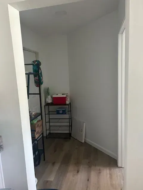 A corner of a room with a cooler on a shelf.