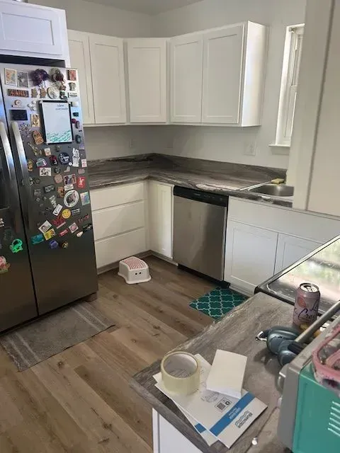 A kitchen with stainless steel appliances and white cabinets.