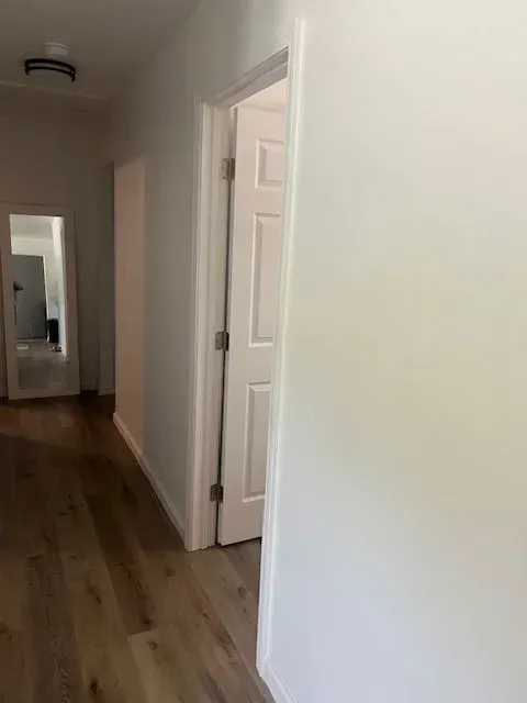 A hallway with a door and a mirror in a house.