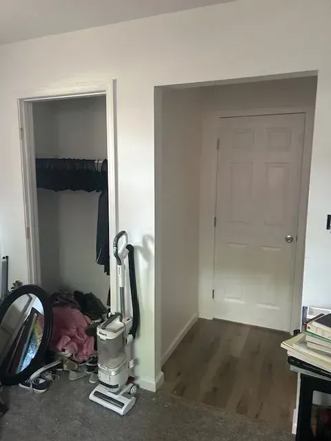 A room with a vacuum cleaner and a mirror in it.