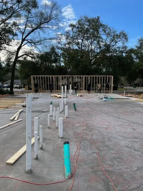 A construction site with a lot of pipes and trees in the background