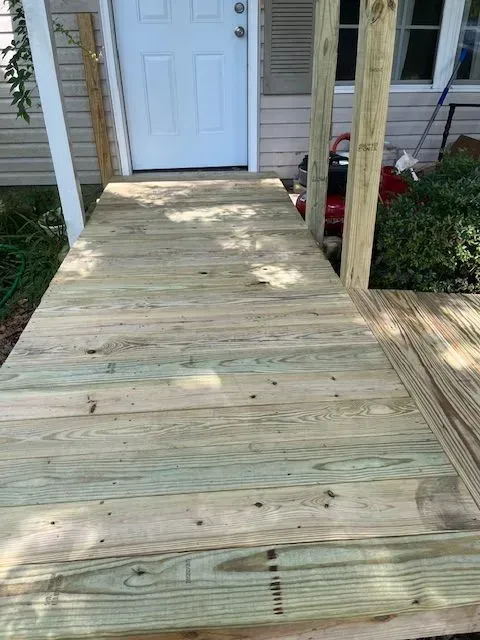 A wooden deck is being built in front of a house.