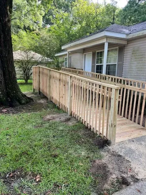 A wooden fence with a ramp leading to a house.